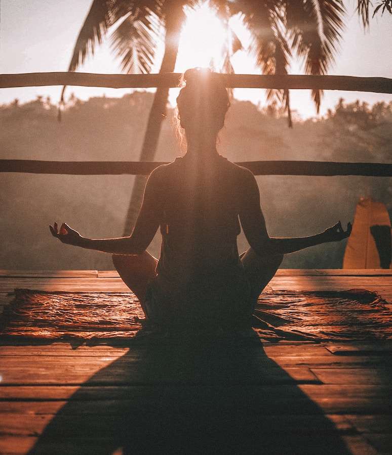 Women doing meditation in front of Sun